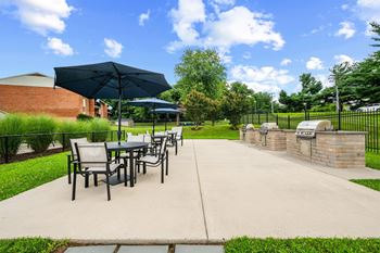 A patio with a table and chairs under an umbrella.